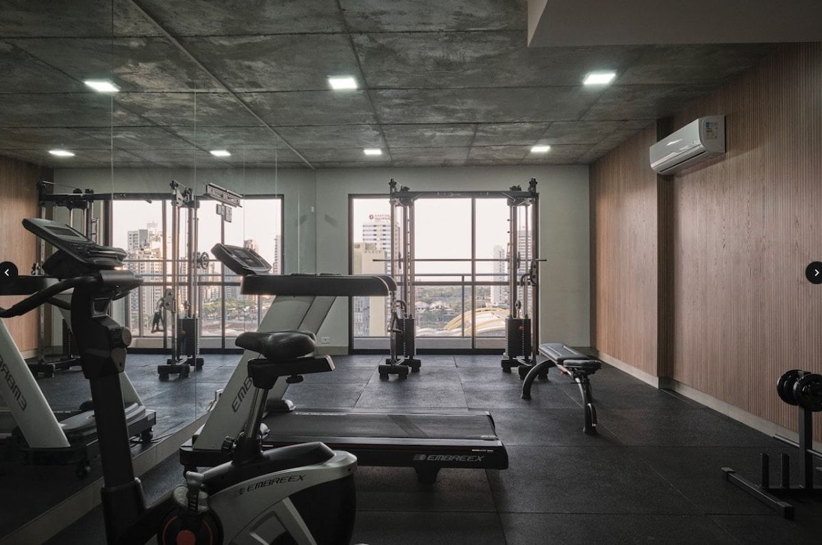 A gym with treadmills, weight machines, and a bench.