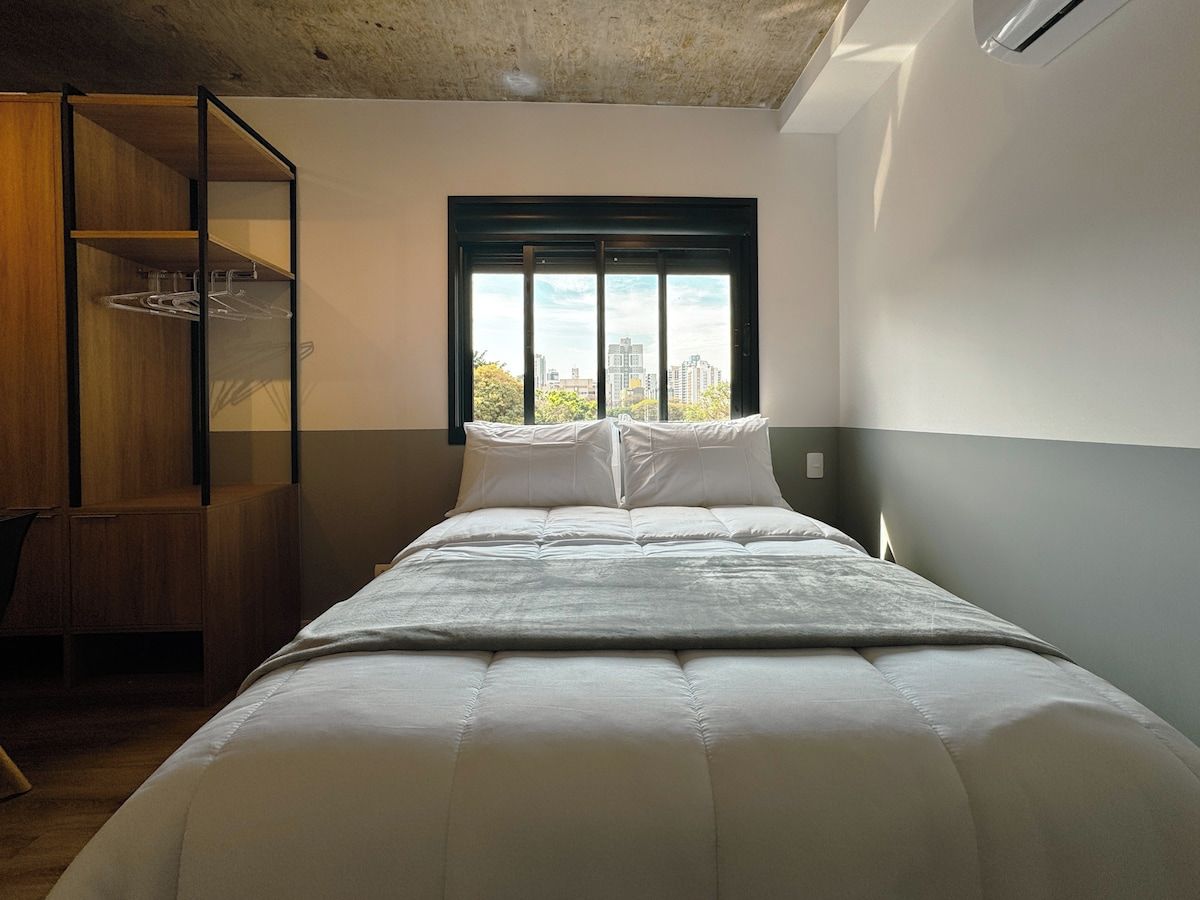 Ein Schlafzimmer mit einem Bett, einem Fenster und einem Holzschrank.
