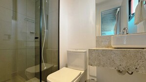 A modern bathroom with a glass-enclosed shower, a white toilet, and a granite countertop sink. - Venha conhecer este ape! - BE-DEO-403 (Maringá)