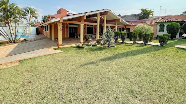 Um edifício de dois andares com varanda coberta e piscina.