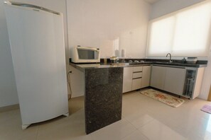 A kitchen with a refrigerator, microwave, sink, and cabinets. - Imperial House with 3 Bedrooms in Maringa - BON705 (Maringá)