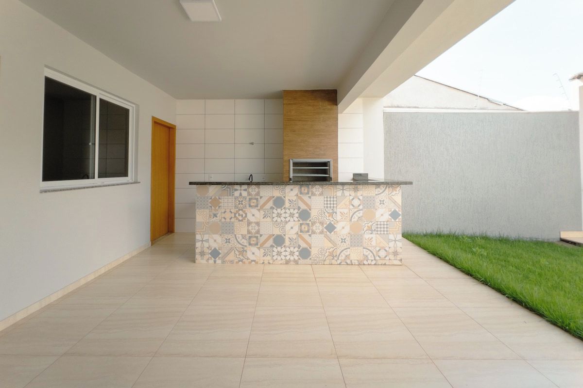 A spacious kitchen with a patterned backsplash, a built-in oven, and a window.