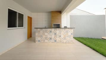 A spacious kitchen with a patterned backsplash, a built-in oven, and a window.