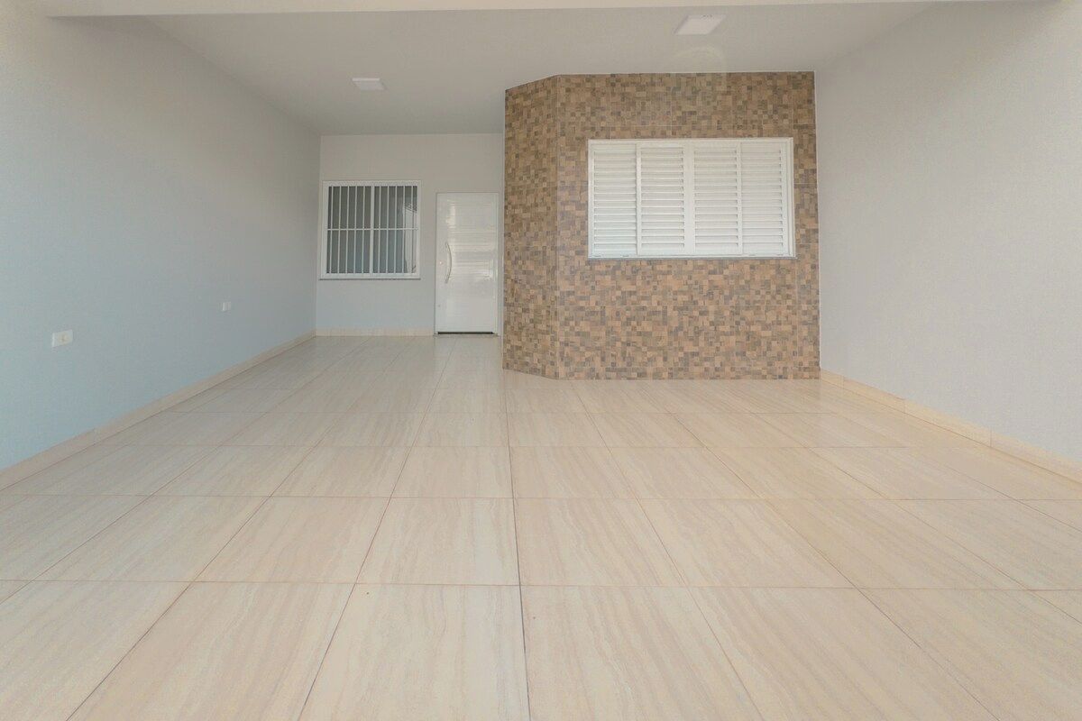 A spacious room with a tiled floor, a door, and a window with blinds.