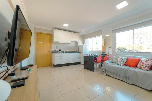 A modern living room with a TV, sofa, and dining area.