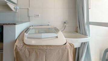 Un baño con encimera, lavamanos y zona de ducha.