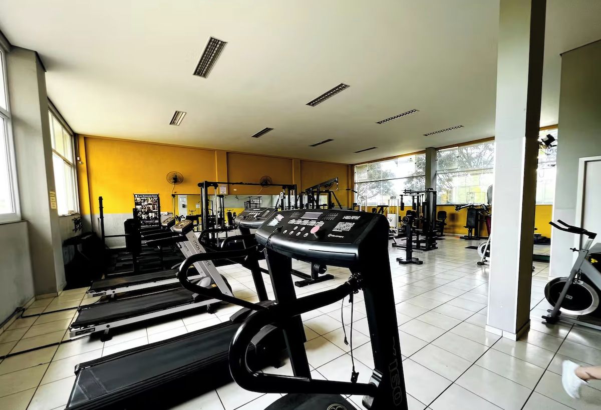 Ein Fitnessstudio mit Laufbändern, Krafttrainingsgeräten und einem Ergometer.