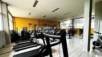 Ein Fitnessstudio mit Laufbändern, Krafttrainingsgeräten und einem Ergometer.