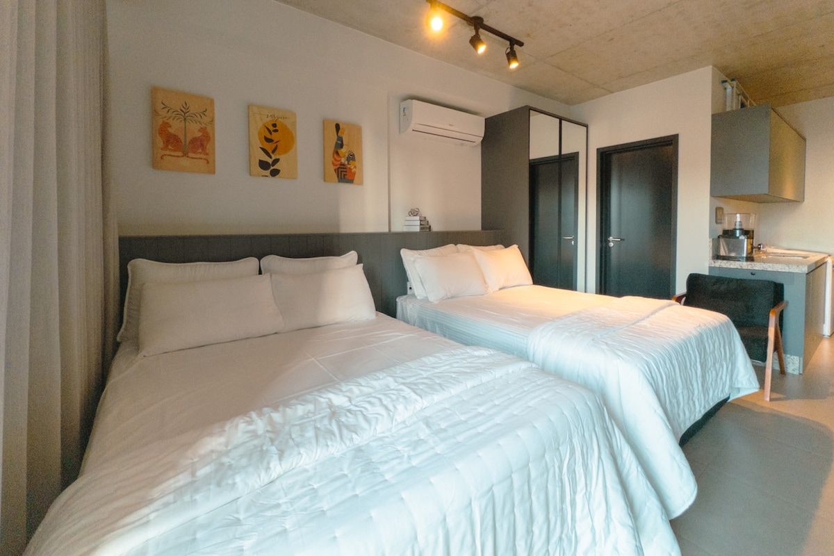 Une chambre d’hôtel avec deux lits, un bureau et une chaise.