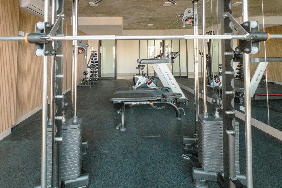 A gym with various exercise equipment, including treadmills and weight machines.