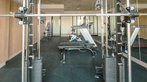 Uma academia com diversos equipamentos de exercício, incluindo esteiras e aparelhos de musculação.