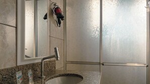 A bathroom with a granite countertop, a sink, a mirror, and a towel rack. - Affordable Apartment with AC in Zona 7 - CED103 (Maringá)