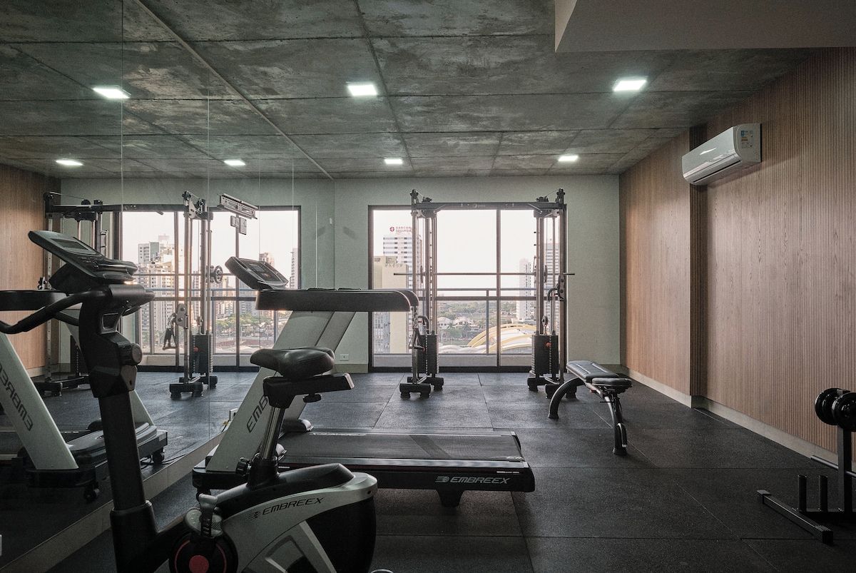 A gym with treadmills, a bench, and weight machines.