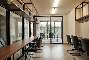 Una sala de conferencias moderna con una larga mesa y sillas, ventanas amplias y vistas al exterior.