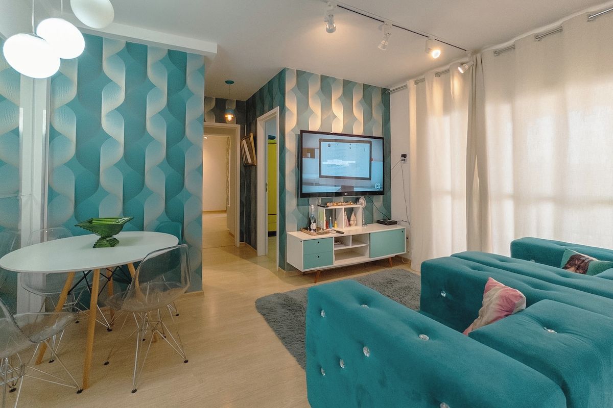 Ein modernes Wohnzimmer mit Fernseher, Sofa und Essbereich.