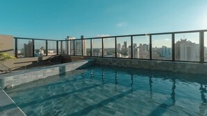 Piscina infinita no terraço com vista para o horizonte da cidade.
