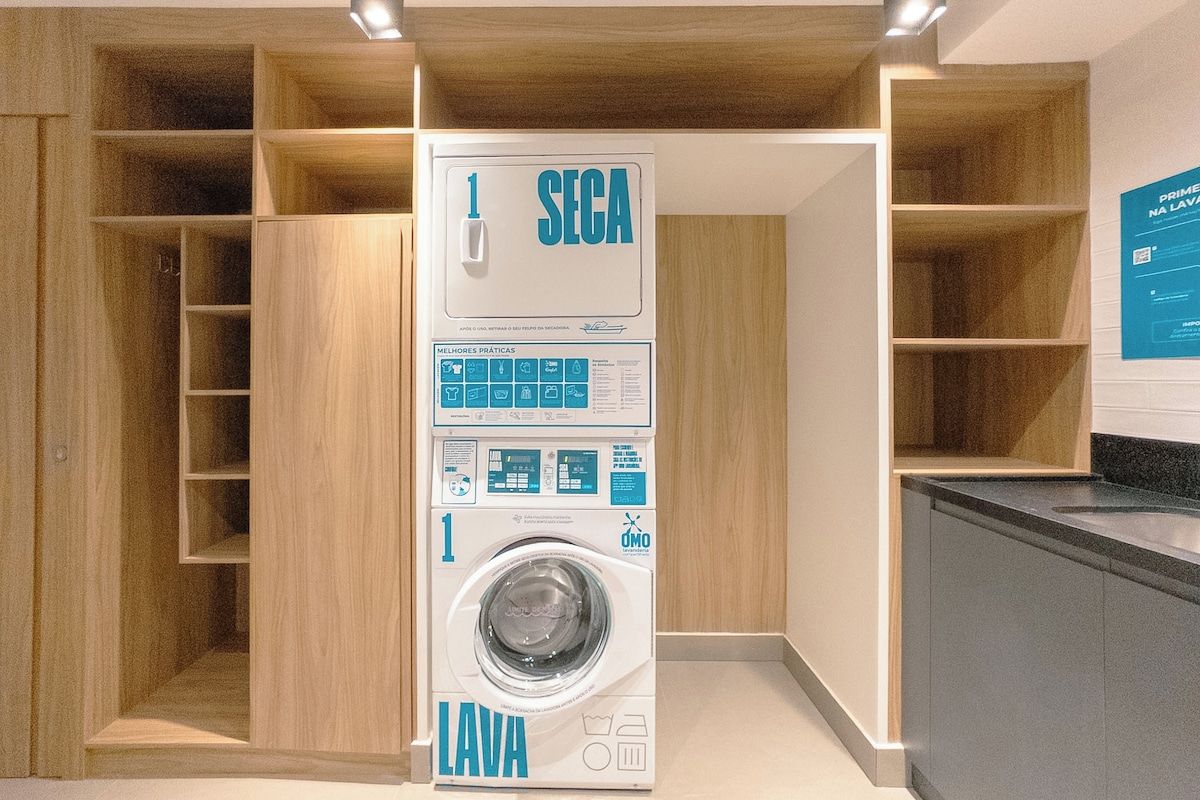 Een moderne wasruimte met een ingebouwde wasmachine, houten planken en een informatief poster aan de muur.