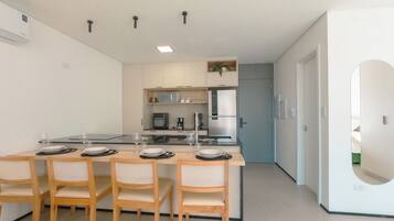 Una cocina moderna con comedor, que presenta una isla central, electrodomésticos integrados y una barra de desayuno.