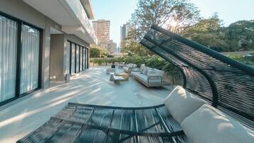 A modern outdoor living area with a sofa, coffee table, and a hammock.