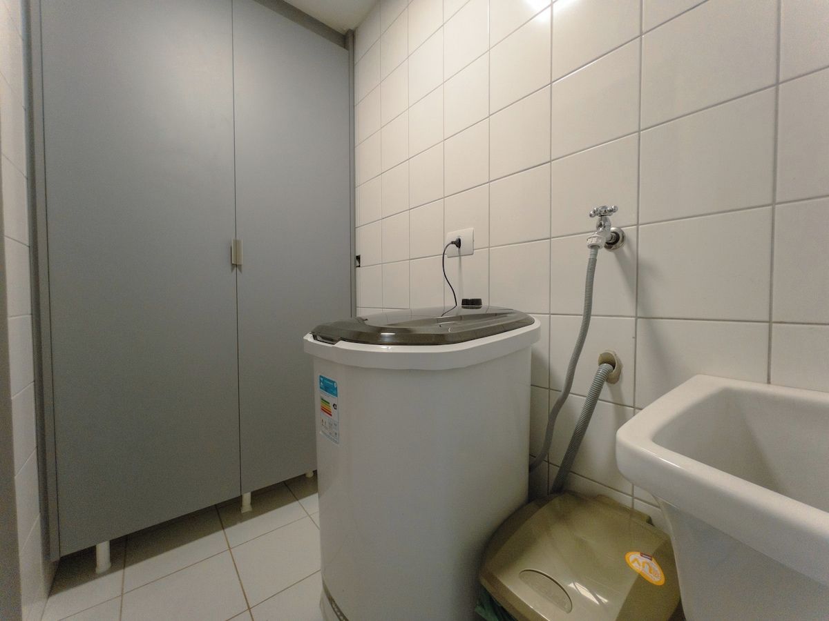 Un baño con inodoro, lavamanos y un cubo de basura.
