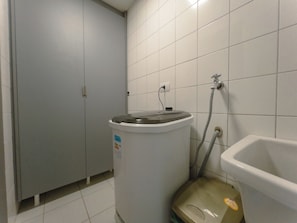 Une salle de bain avec des toilettes, un lavabo et une poubelle.