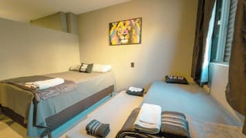 Ein Hotelzimmer mit zwei Betten, einem Bild an der Wand und einem Fenster mit Vorhängen.