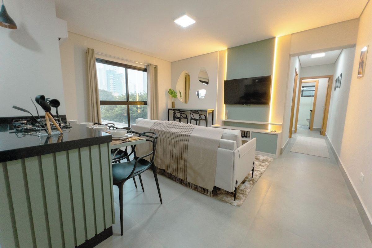 A modern living room with a sofa, a dining table, and a TV.