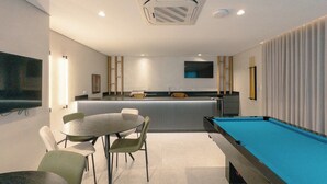 A modern room with a pool table, a dining area, and a kitchen. - Design and Modern Living in Downtown Maringa - NEO204 (Maringá)