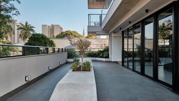 Um edifício moderno com telhado plano, grandes janelas e um pequeno jardim com plantas.