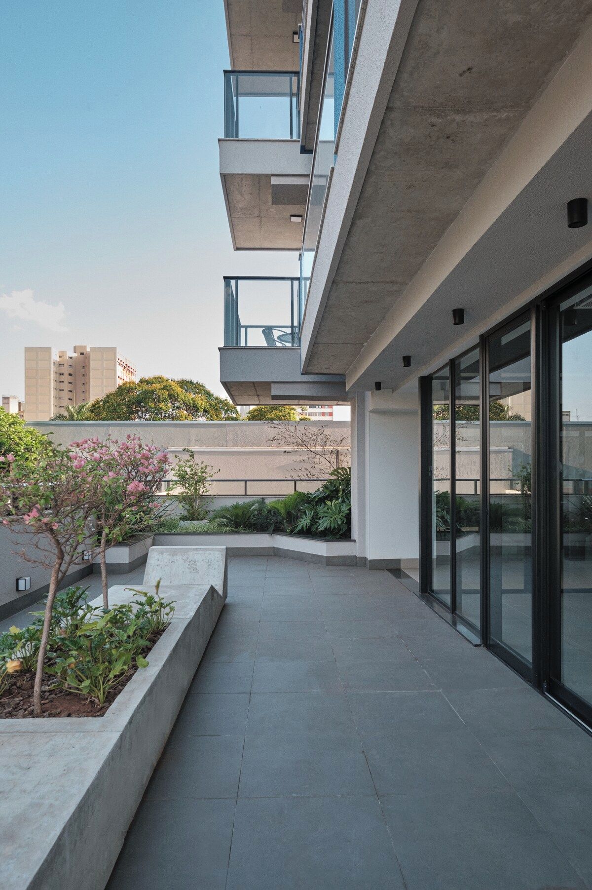 Un edificio moderno con techo plano, ventanas grandes y fachada de hormigón.