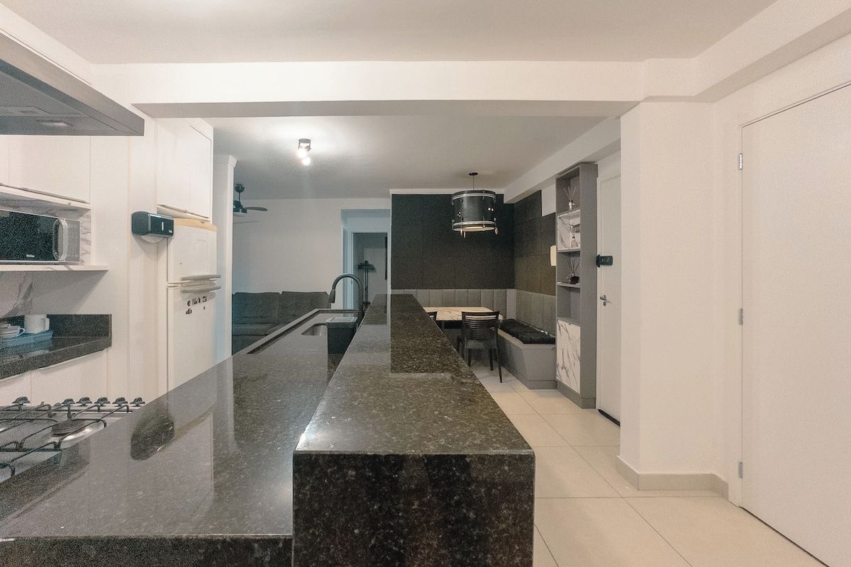 Eine moderne Küche mit Granit-Arbeitsplatte, integriertem Herd und einem Essbereich mit Tisch und Stühlen.