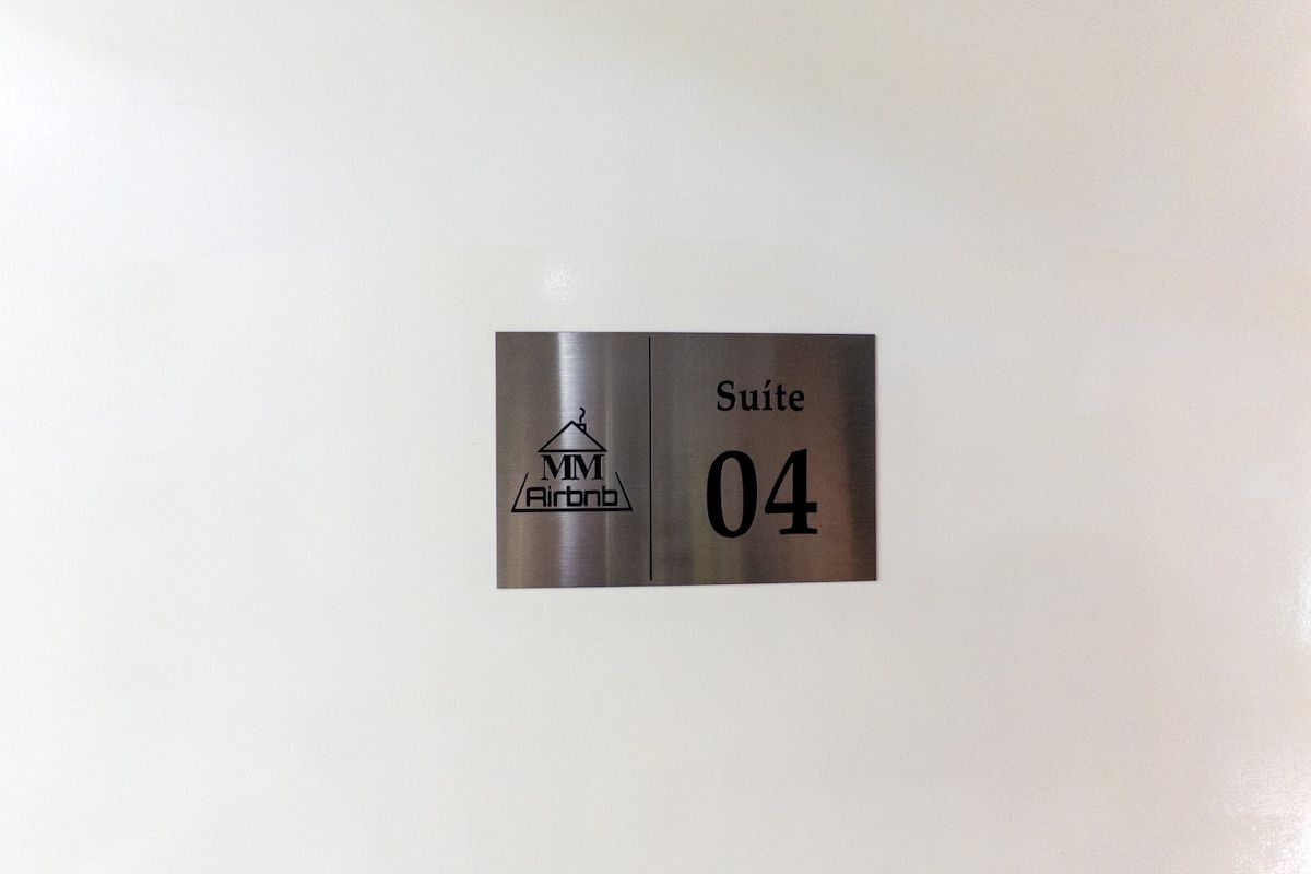 A metallic sign with the text 'Suite 04' and the logo 'MM Airbnb'.