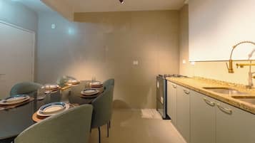 Uma cozinha moderna com bancada de granito, pia de aço inoxidável e forno embutido.