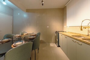A modern kitchen with a granite countertop, stainless steel sink, and a built-in oven.