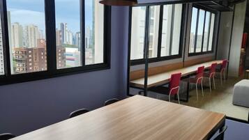 A conference room with a long table, chairs, and pendant lighting.