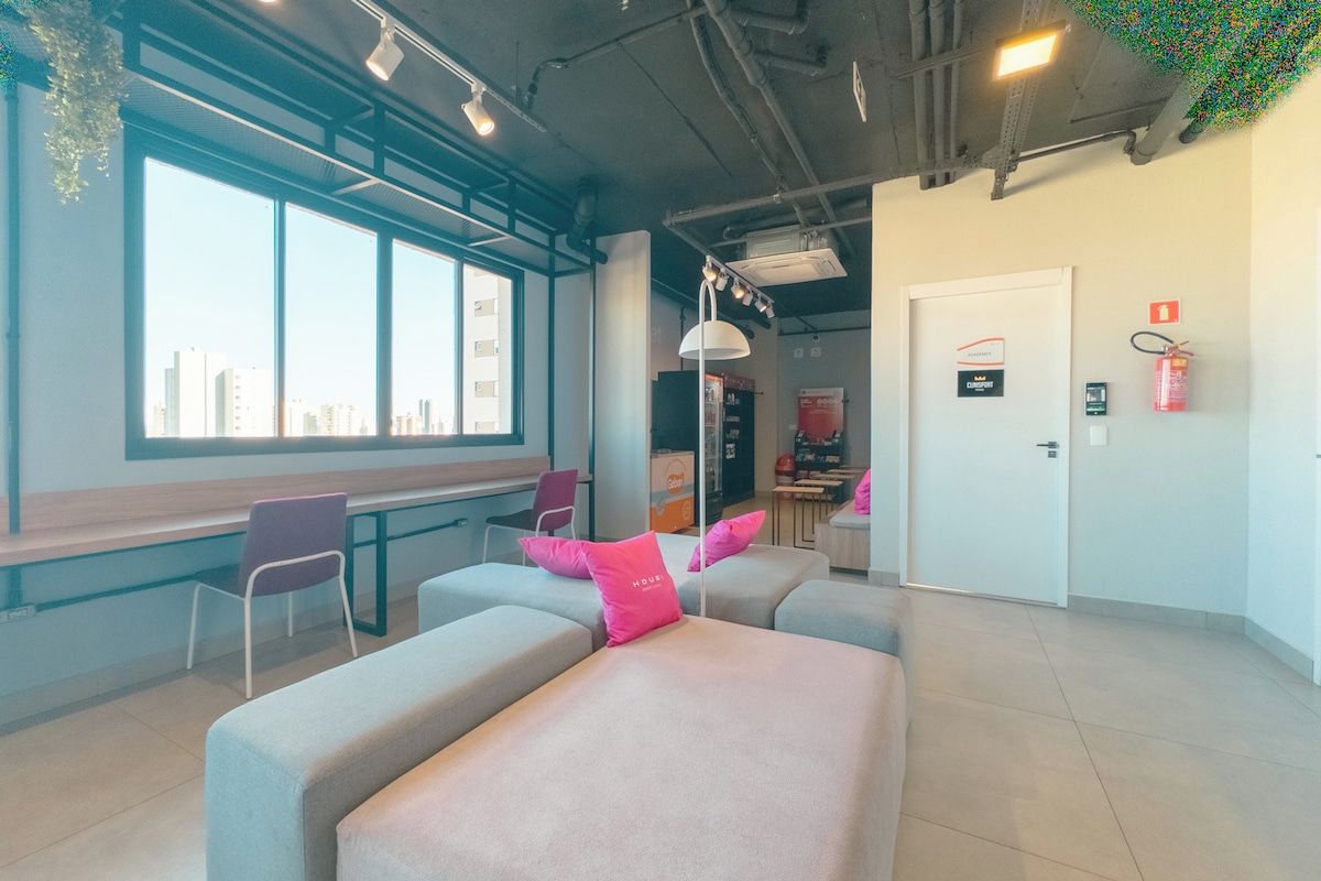 Un moderno vestíbulo de hotel con áreas de estar, un mostrador de recepción y vistas de la ciudad.