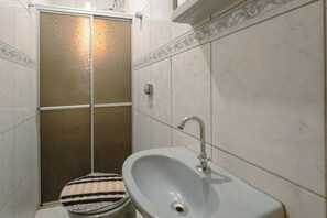 A bathroom with a shower, a sink, and a toilet.