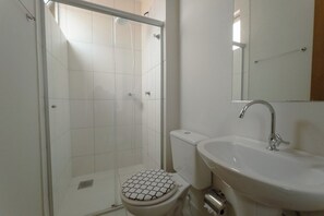 Kylpyhuoneessa on lasiseinällä varustettu suihku, wc ja pesuallas, jonka yläpuolella on peili.