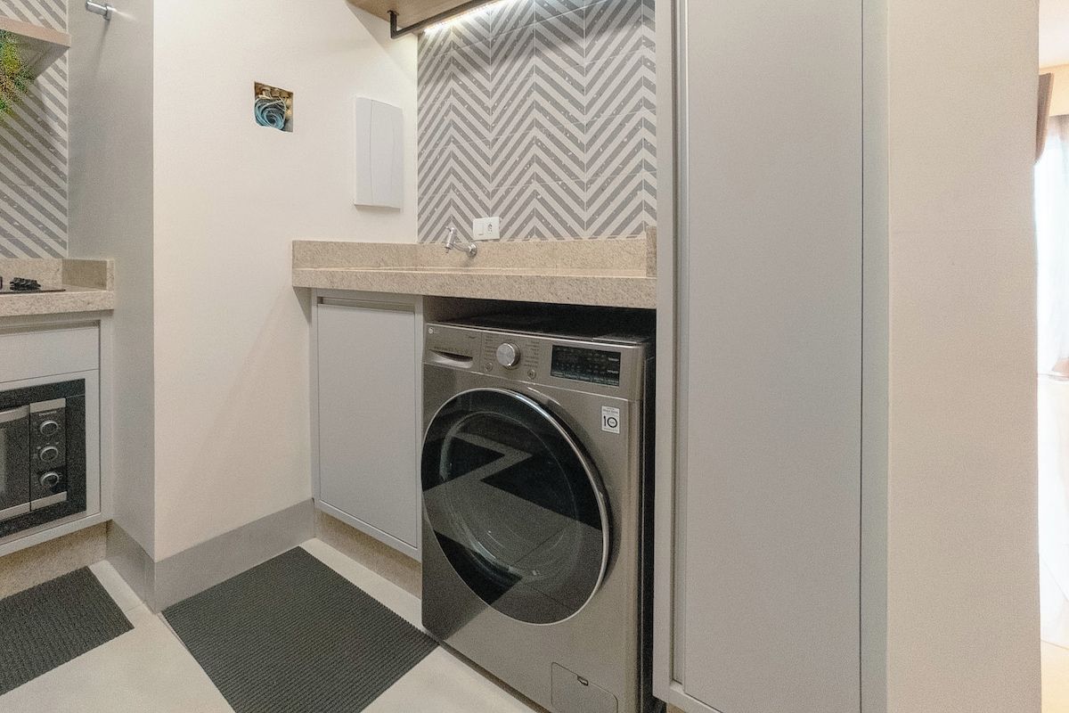 A compact laundry room with a washing machine, a dryer, and a small countertop.