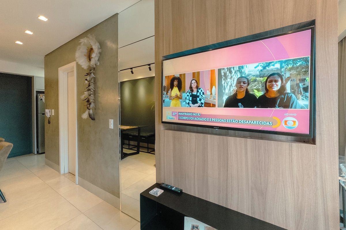A television mounted on a wall displaying a news program.