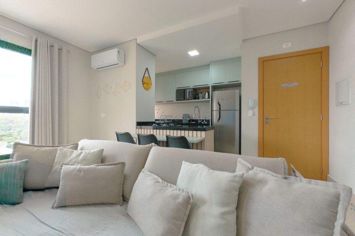 Een moderne woonkamer met een bank en een eethoek op de achtergrond.
