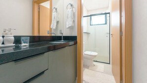Uma casa de banho moderna com lavatório, espelho e sanita.