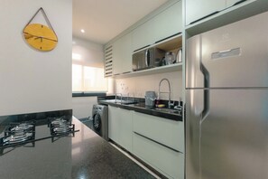 Een moderne keuken met roestvrijstalen apparatuur, een magnetron en een ingebouwde oven.