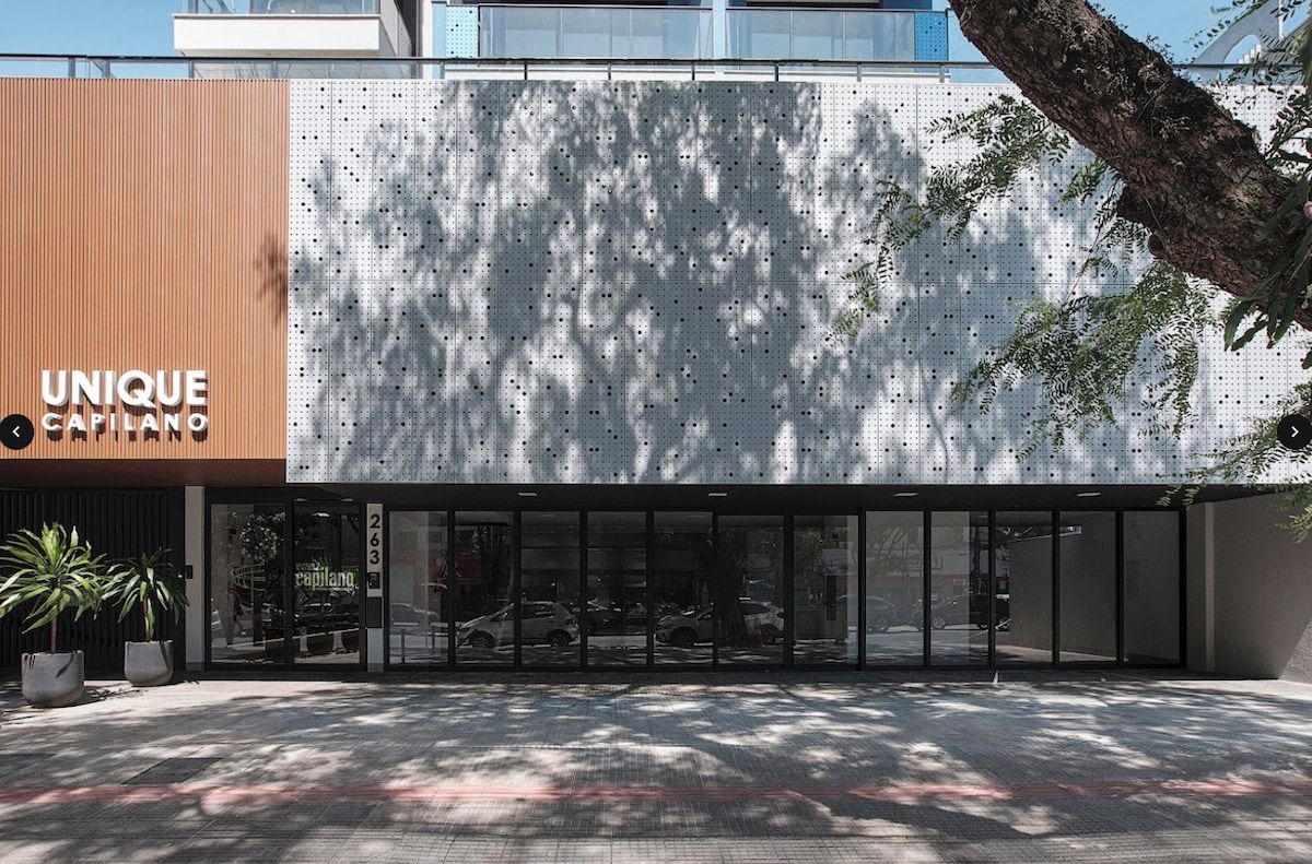 A modern building with a unique facade, large glass entrance, and a visible address number.