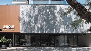 A modern building with a unique facade, large glass entrance, and a visible address number. - Stay in Style in Downtown Maringa - CA1302 (Maringá)