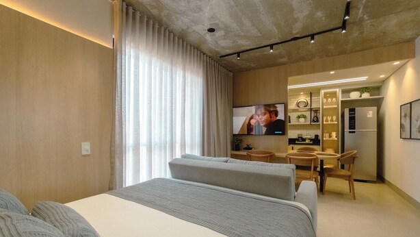 A modern hotel room with a large bed, a desk, and a television. - Stay in Style in Downtown Maringa - CA1302 (Maringá)