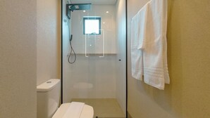 A compact bathroom with a glass-enclosed shower, a toilet, and a towel hanging on the wall. - Stay in Style in Downtown Maringa - CA1302 (Maringá)