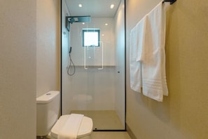 A compact bathroom with a glass-enclosed shower, a toilet, and a towel hanging on the wall. - Stay in Style in Downtown Maringa - CA1302 (Maringá)