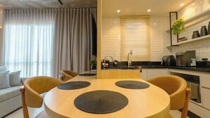 A modern kitchen with a round dining table, chairs, and a built-in oven. - Stay in Style in Downtown Maringa - CA1302 (Maringá)