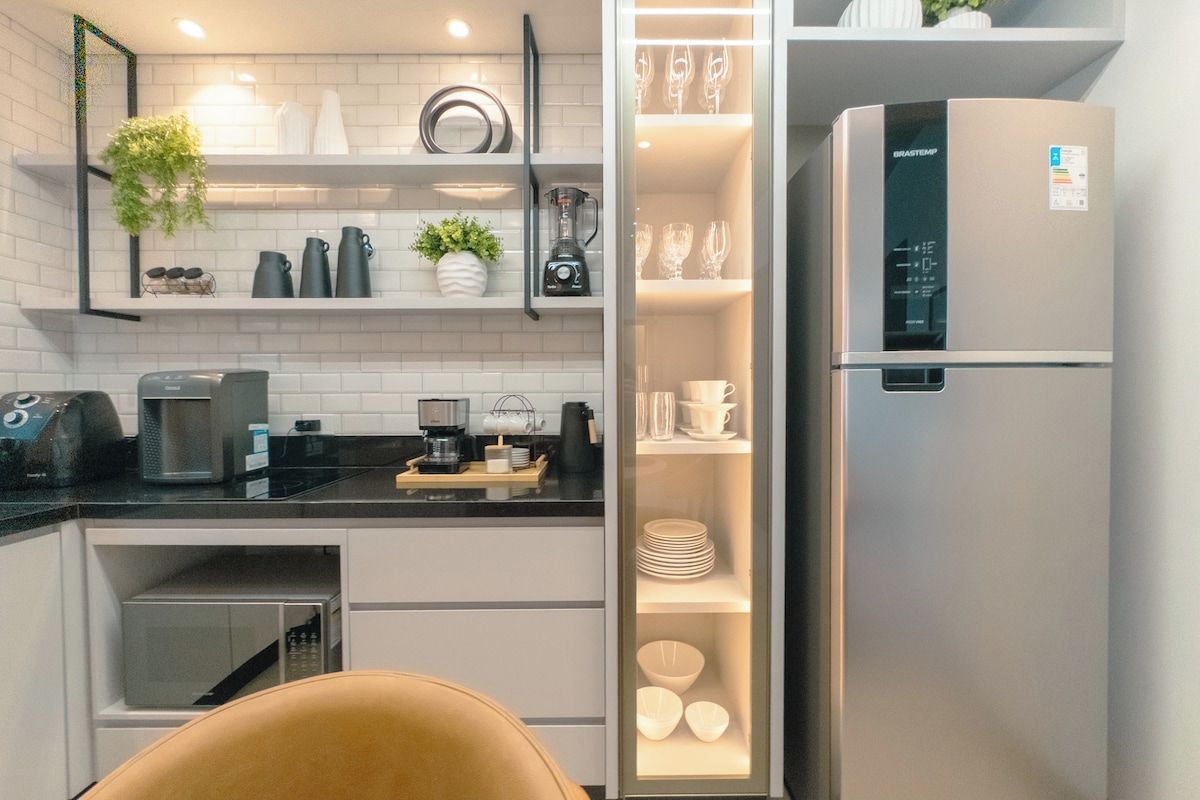 A modern kitchen with a built-in refrigerator, a coffee machine, and a variety of kitchenware.